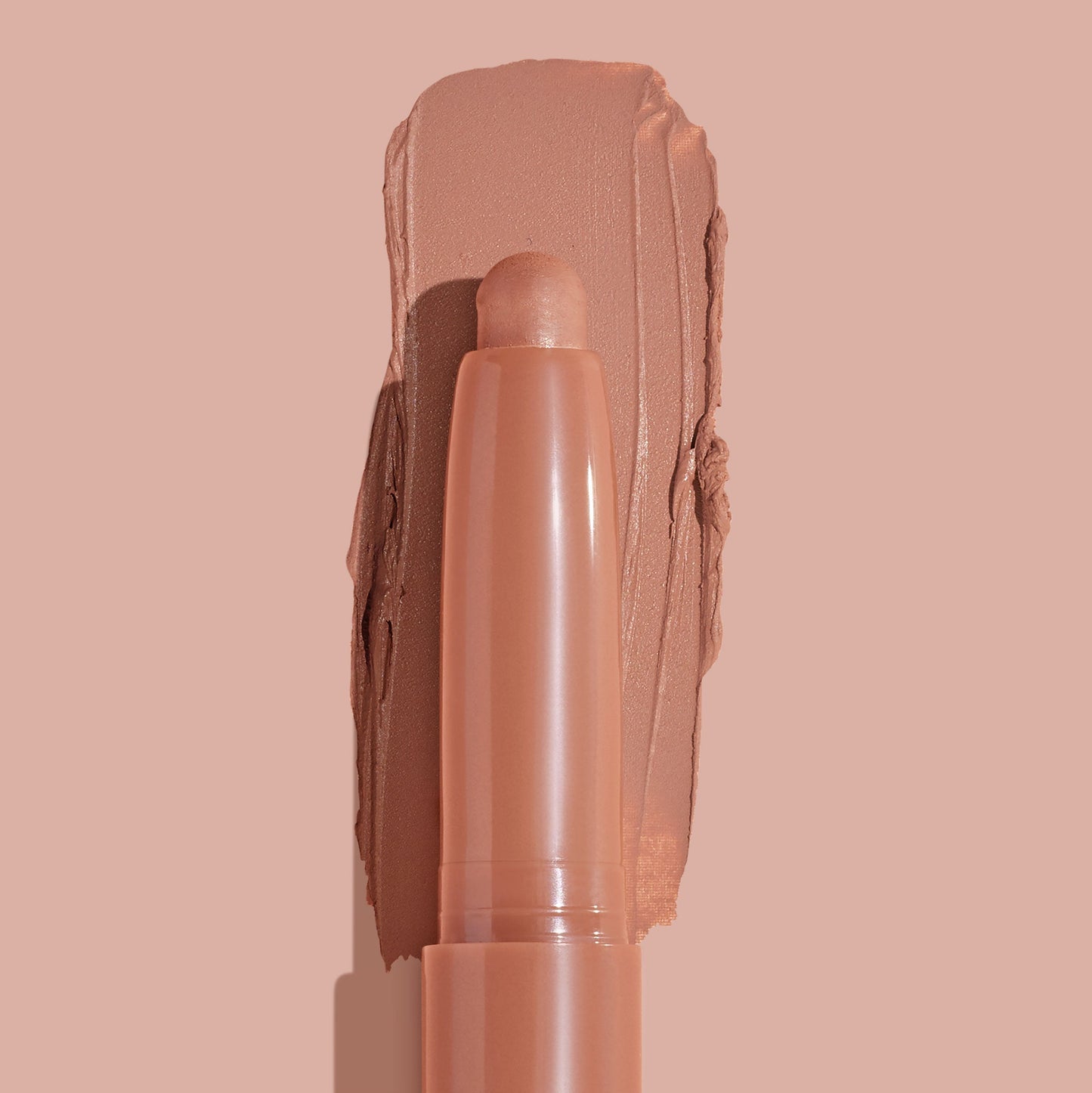 ColourPop Shadow Stix in Bare With Me smoothly swiped into a thick matte peachy-nude swatch, the crayon tip centered in close-up on a matching nude background, highlighting the creamy, long-wear eyeshadow stick.