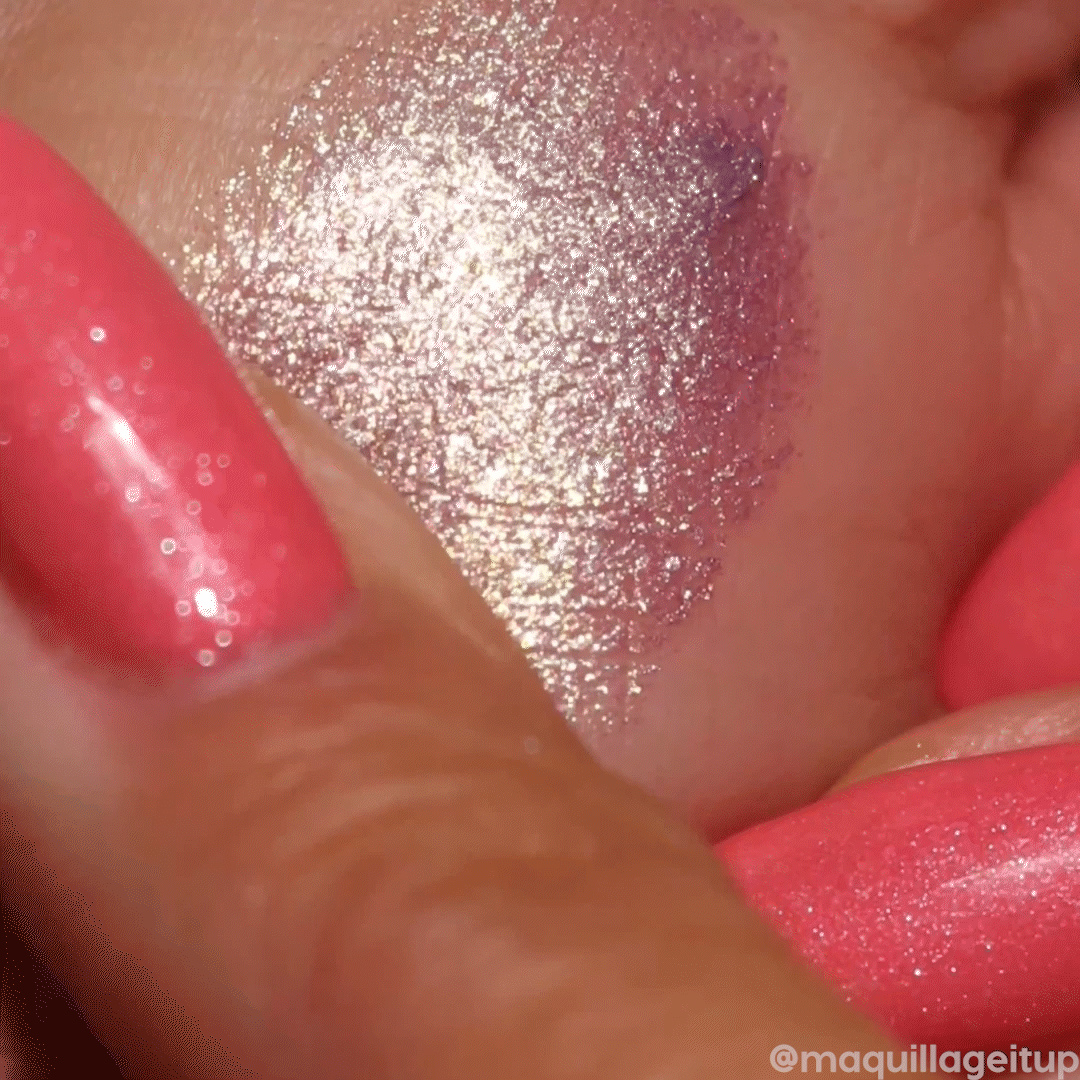 Big Ego ColourPop Jelly Much Shadow swatch shimmering lavender-to-gold duochrome, high-shine metallic payoff on skin, spread in a smooth jelly texture on the back of a hand, shown next to coral glitter nails.