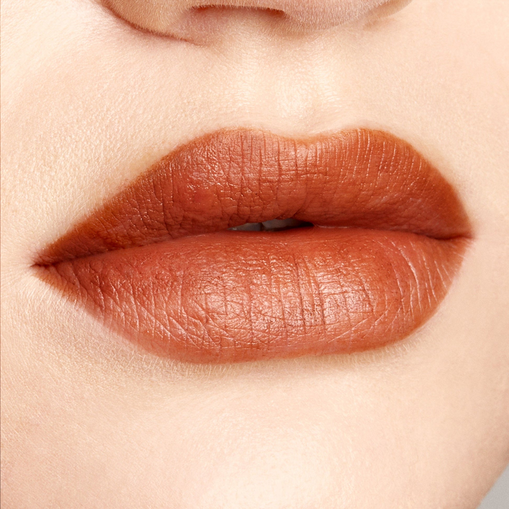 Full lips wearing BFF3, a warm terracotta brown, precisely lined and filled with the ColourPop Lippie Pencil, showing a smooth matte finish in a tight close-up against neutral skin for a rich, defined lip look.